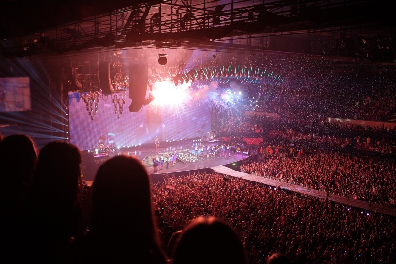 Eine Halle voll mit Menschen und eine Bühne.